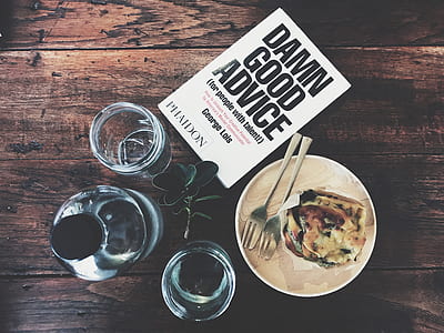 cooked food beside gray stainless steel fork and spoon on white ceramic plate beside three glass jars and Damn Good Advice book thumbnail