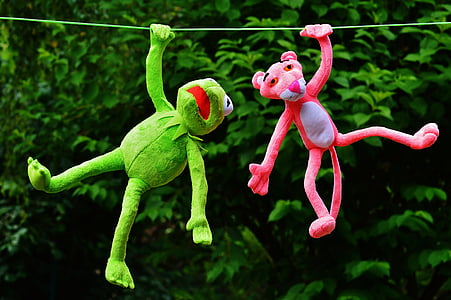 pink panther plush toy beside green frog plush toy hanging on rope thumbnail