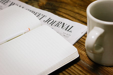 white notebook beside white mug thumbnail