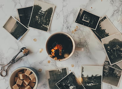 top-view photograph of ceramic cup and stack of photographs thumbnail