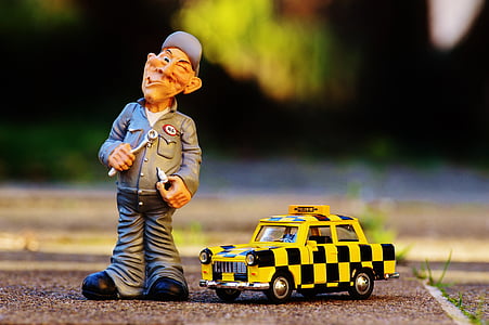 yellow and black Taxi toy beside mechanic man figure thumbnail