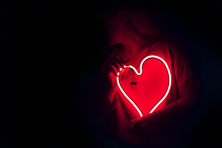 person holding red heart neon signage thumbnail
