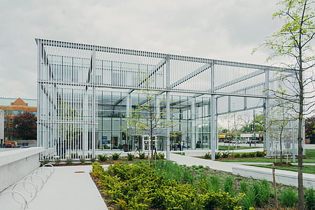 white glass wall building surround by plants and trees thumbnail