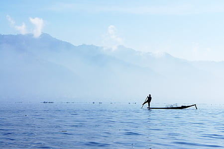 silhouette photography of person on canoe holding oar thumbnail