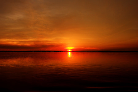 silhouette photography of body of water during golden hour thumbnail