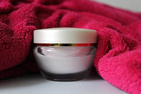 white cream jar beside red towel on white surface thumbnail