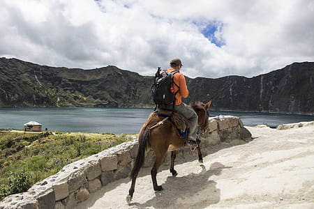 Man carrying a bag pack Riding a Brown Horse thumbnail