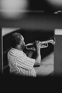 grayscale photography of man playing trumpet thumbnail