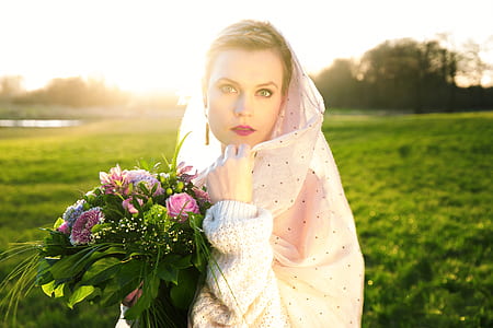 woman in white dress holding flowers thumbnail