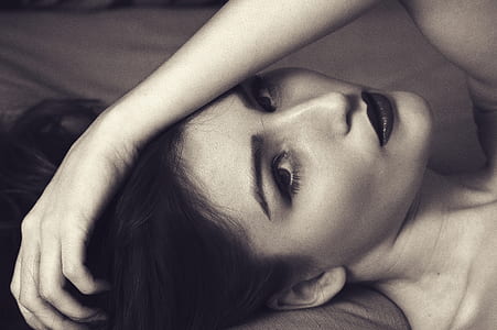grayscale photography of woman lying on bed thumbnail