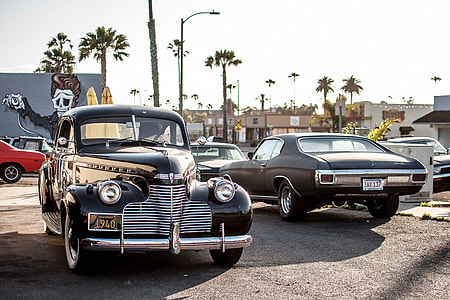 black vintage car beside brown classic coupe under clear blue sky during daytime thumbnail
