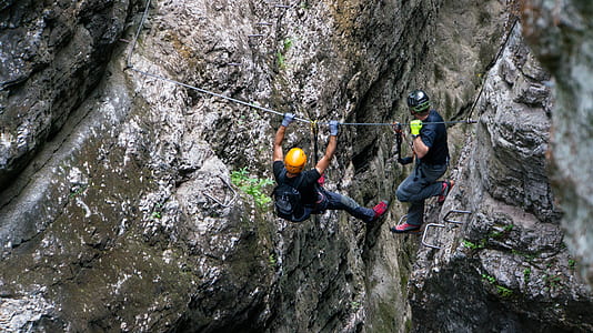 two people climbing on gray rock formation thumbnail