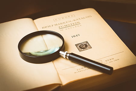 black magnifying glass on book page thumbnail