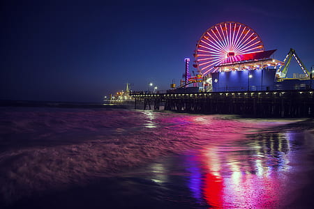 Carnival with Ferris Wheel near body of water during nighttime thumbnail