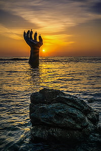 hand drown in ocean during golden hour thumbnail