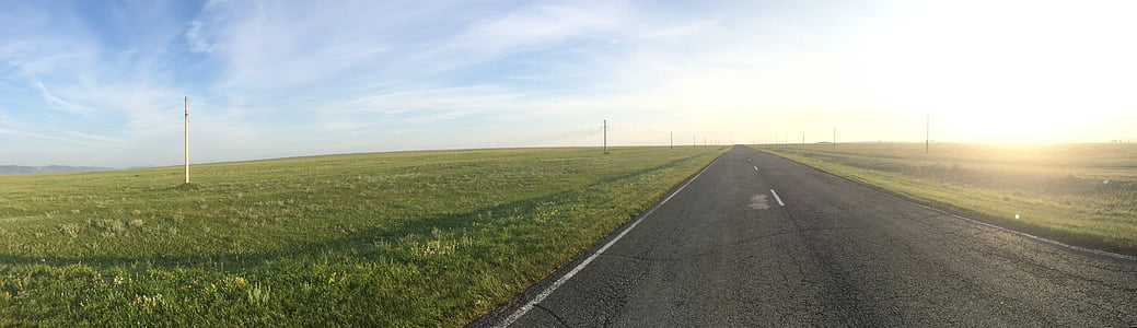 gray concrete pathway surrounded by green grass field thumbnail