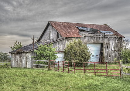 brown wooden house surrounded by grass thumbnail