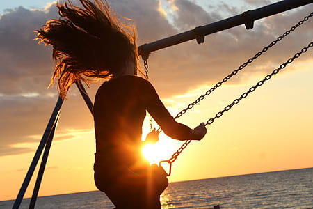 person riding a swing near beach thumbnail
