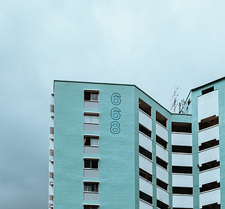teal and white 668 concrete high-rise building under cloudy sky during daytime thumbnail