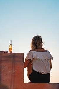 woman in white off-shoulder top sitting on bench thumbnail