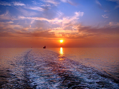 silhouette of photo of boat at sea during golden hour thumbnail