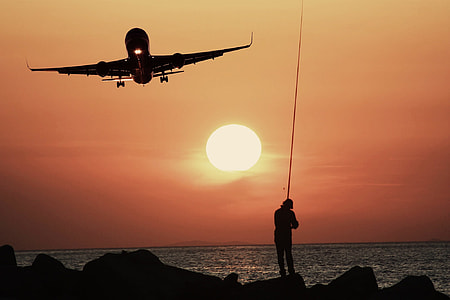 person fishing under airliner during golden hour thumbnail