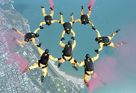 group of people parachuting over city near water thumbnail