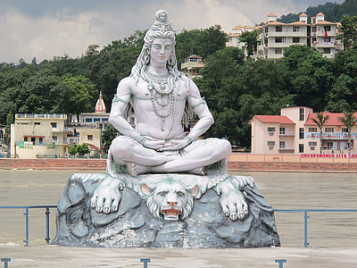 statue of Hindu Deity sitting on white tiger near river thumbnail