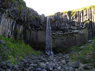 rocks below waterfalls during day thumbnail