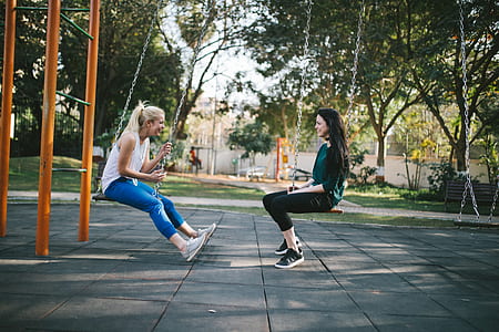 two women seating on swings thumbnail