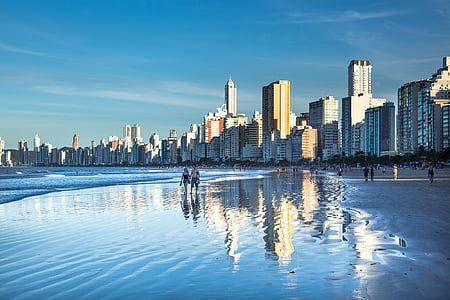 landscape photography of people walking on seashore thumbnail
