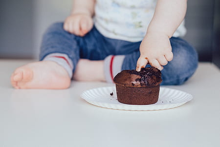 toddler putting finger in chocolate muffin thumbnail