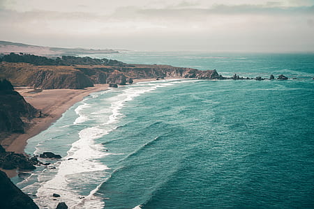 aerial photography of seashore near mountain thumbnail