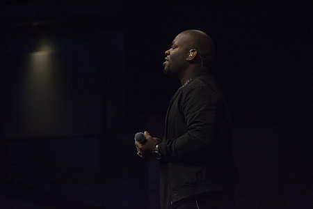 man wearing black shirt singing on stage thumbnail