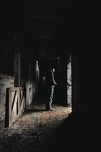 man standing inside horse stable thumbnail