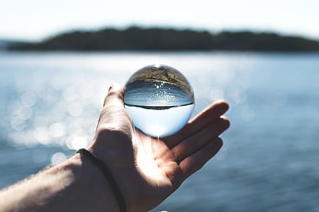 Bokeh Photography of Person Holding Water Drop thumbnail