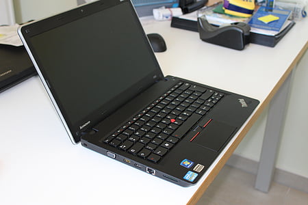 black Lenovo Thinkpad on top of white wooden desk thumbnail