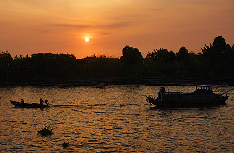 silhouette of boats near tree during golden hour thumbnail