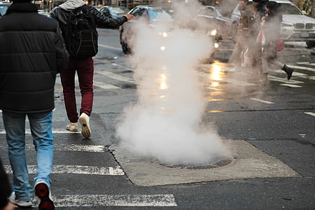 people walking on pedestrian lane besides sewer thumbnail