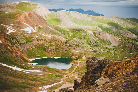 body of water beside green mountain thumbnail