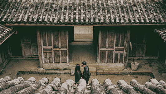 man and woman standing beside house thumbnail
