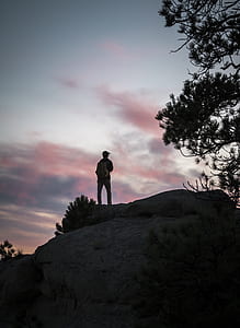 man standing on top of gray boulder thumbnail