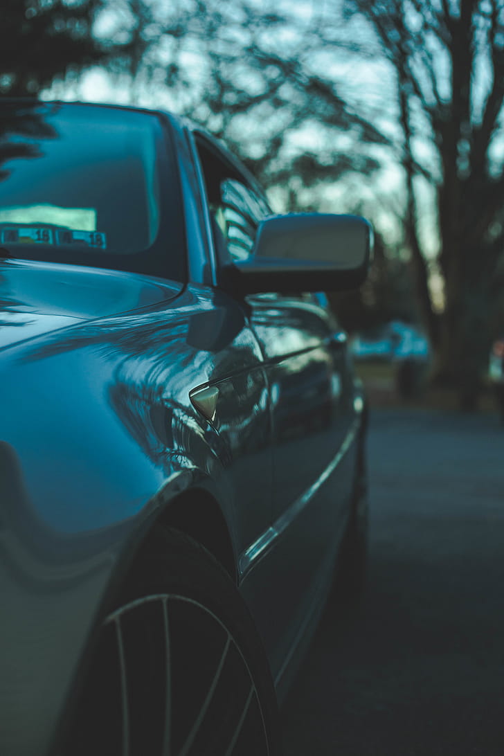 Selective Focus Photography of Gray Vehicle Parked Under Shade of Tree