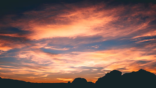 silhouette of mountain range under orange clouds at sunset thumbnail