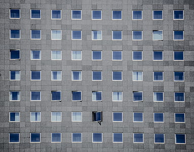 gray concrete building with clear glass windows thumbnail