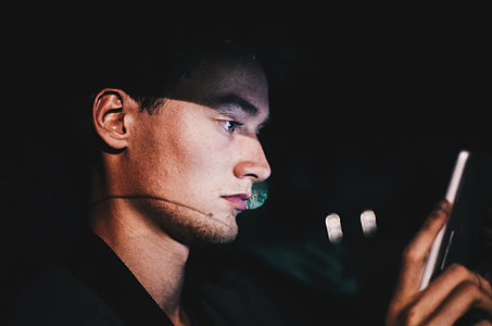 close-up photography of man looking on white smartphone thumbnail