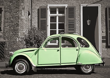 green Volkswagen Beetle parked near white painted wall and black wooden door thumbnail