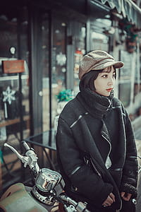 focal focus photography of female sitting on motor scooter thumbnail