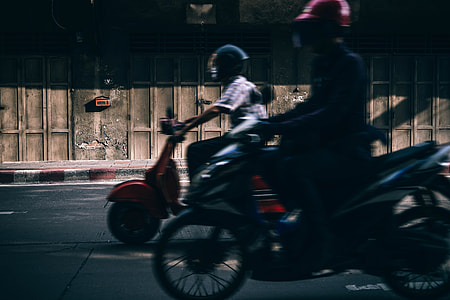 man riding red motor scooter on road thumbnail
