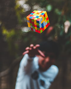 shallow depth of field photo of person throwing 5 by 5 Rubik's Cube thumbnail